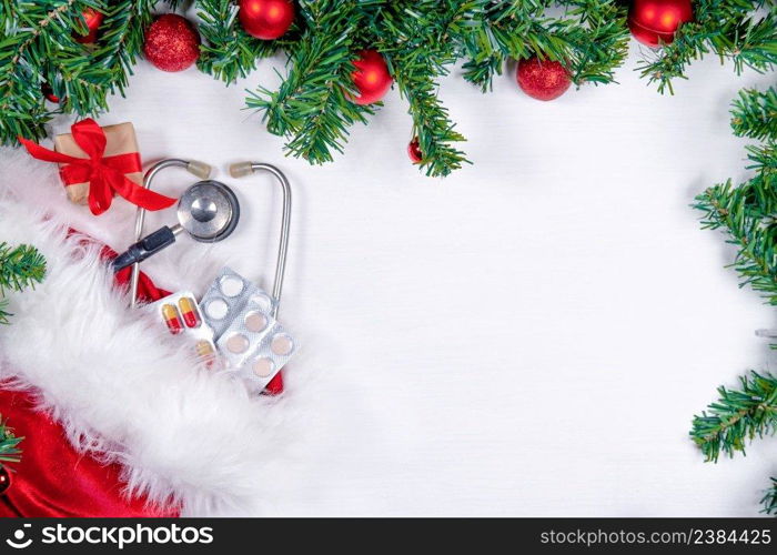 Medical banner with pills, gift present box, stethoscope and Christmas tree on white wooden background. Copyspace. Medicine new year flatly.. Medical banner with pills, gift present box, stethoscope and Christmas tree on white wooden background. Copyspace. Medicine new year flatly