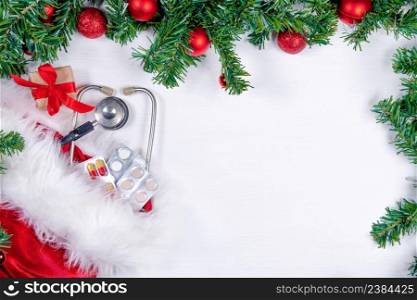 Medical banner with pills, gift present box, stethoscope and Christmas tree on white wooden background. Copyspace. Medicine new year flatly.. Medical banner with pills, gift present box, stethoscope and Christmas tree on white wooden background. Copyspace. Medicine new year flatly