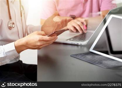 Medical co working concept,Doctor working with smart phone and digital tablet and laptop computer to meeting his team in modern office at hospital