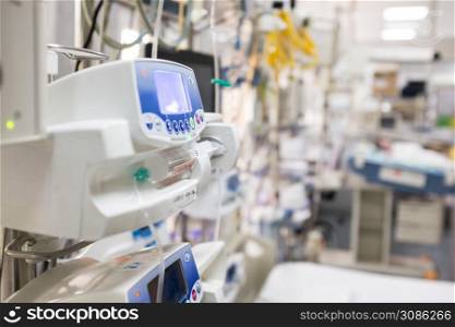 Medical device in UK NHS EMS ICU hospital room,infusion pump dripping intravenous fluid,US Coronavirus COVID-19 epidemic pandemic,clinic quarantine isolation,blurred out of focus background,copy space