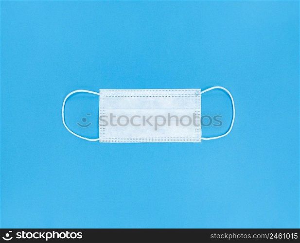 Medical disposable face mask on a blue background.. Medical disposable face mask on blue background.
