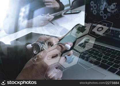 medical doctor hand working with smart phone,digital tablet computer,stethoscope eyeglass,on wooden desk,virtual graphic interface icons screen