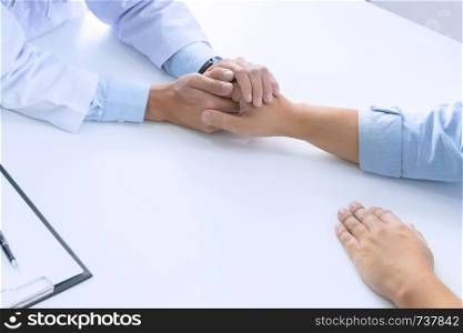 Medical doctor holding a patient hand in hospital.