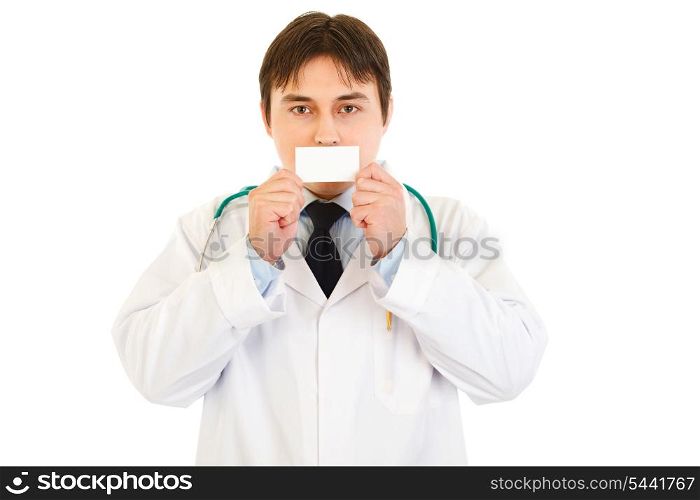 Medical doctor holding blank business card in front of mouth isolated on white&#xA;