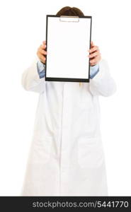 Medical doctor holding blank clipboard in front of her face isolated on white&#xA;