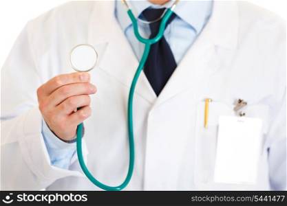 Medical doctor holding up stethoscope isolated on white. Close-up.&#xA;