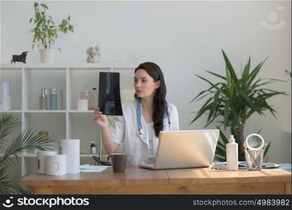 Medical doctor looking at xray of patient elbow at office