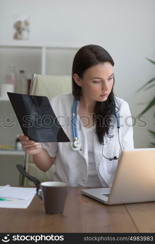 Medical doctor looking at xray of patient elbow at office