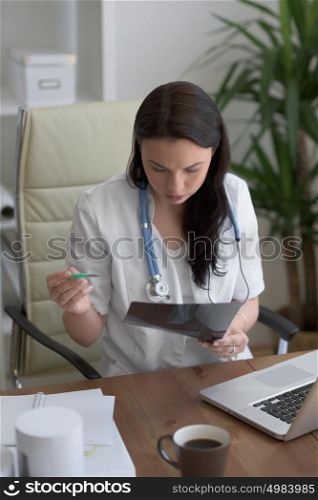 Medical doctor looking at xray of patient elbow at office