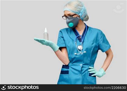 medical doctor nurse wearing protective mask - holding bottle of sanitizing spray or gel.. medical doctor nurse wearing protective mask - holding bottle of sanitizing spray or gel