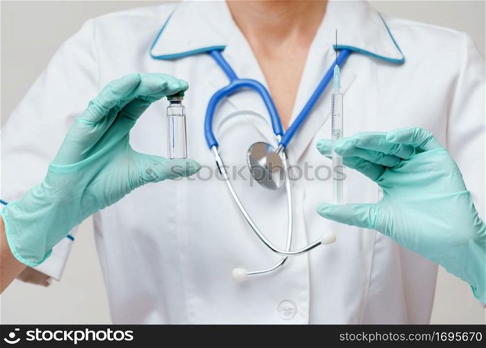 medical doctor nurse woman wearing protective mask and gloves - holding bottle of vaccine medicine and syringe.. medical doctor nurse woman wearing protective mask and gloves - holding bottle of vaccine medicine and syringe