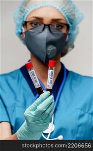 medical doctor nurse woman wearing protective mask and gloves - holding negative and positive coronavirus COVID-19 blood test.. medical doctor nurse woman wearing protective mask and gloves - holding negative and positive coronavirus COVID-19 blood test