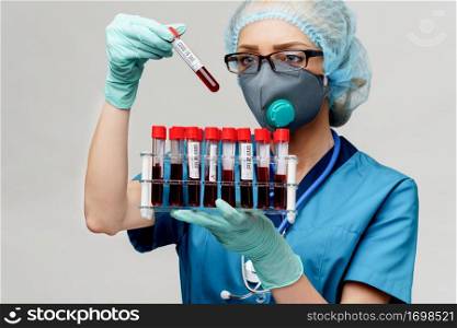 medical doctor nurse woman wearing protective mask and gloves - holding rack with virus blood tests.. medical doctor nurse woman wearing protective mask and gloves - holding rack with virus blood tests