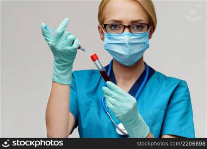 medical doctor nurse woman wearing protective mask and gloves - holding virus blood test tube and syringe.. medical doctor nurse woman wearing protective mask and gloves - holding virus blood test tube and syringe