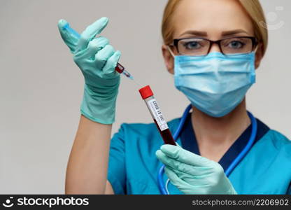 medical doctor nurse woman wearing protective mask and gloves - holding virus blood test tube and syringe.. medical doctor nurse woman wearing protective mask and gloves - holding virus blood test tube and syringe