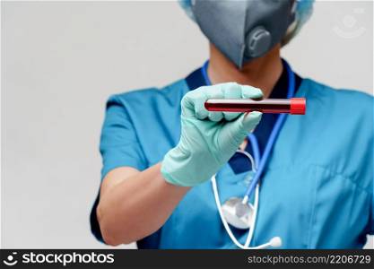 medical doctor nurse woman wearing protective mask and gloves - holding virus blood test tube.. medical doctor nurse woman wearing protective mask and gloves - holding virus blood test tube