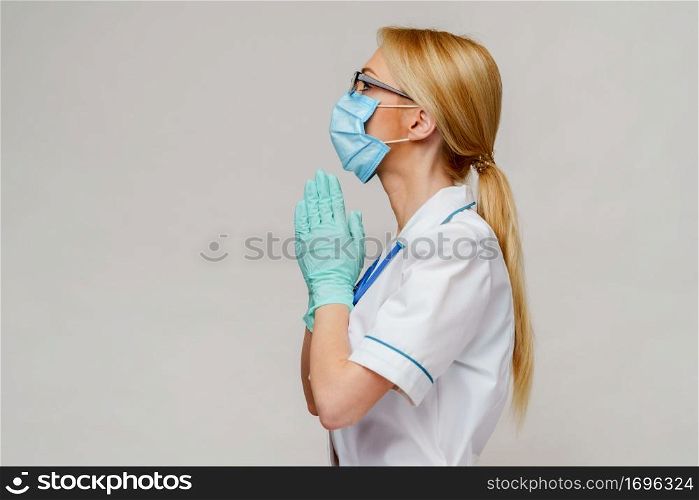 medical doctor nurse woman wearing protective mask and rubber or latex gloves - holding pills.. medical doctor nurse woman wearing protective mask and latex gloves - praying nad hoping gesture