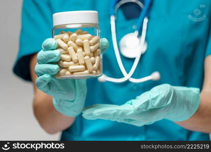 medical doctor nurse woman wearing protective mask and rubber or latex gloves - holding pills.. medical doctor nurse woman wearing protective mask and rubber or latex gloves - holding pills