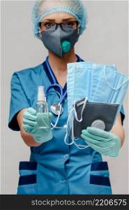 medical doctor nurse woman with stethoscope - holding protective mask and sanitizer.. medical doctor nurse woman with stethoscope - holding protective mask and sanitizer
