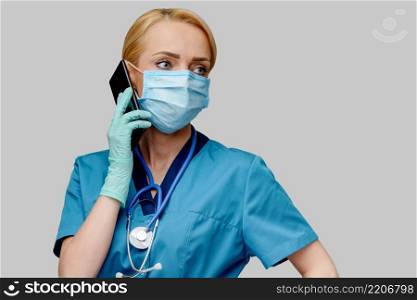 medical doctor nurse woman with stethoscope wearing protective mask and rubber or latex gloves talking on mobile cell phone.. medical doctor nurse woman with stethoscope wearing protective mask and rubber or latex gloves talking on mobile cell phone