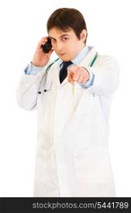 Medical doctor talking on mobile phone and pointing finger at you isolated on white&#xA;