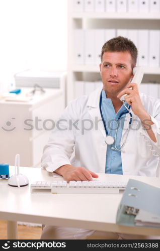Medical doctor talking on phone at office.
