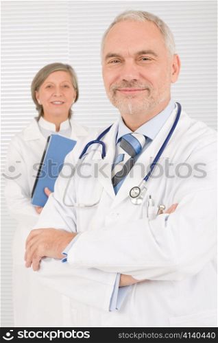 Medical doctor team mature woman and senior man holding folders