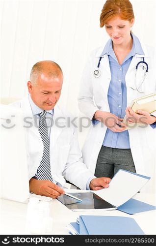 Medical doctor team senior man with female colleague look x-ray