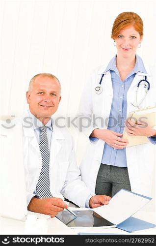 Medical doctor team senior man with female colleague point x-ray