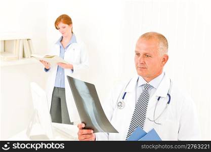 Medical doctor team senior man with female nurse look x-ray