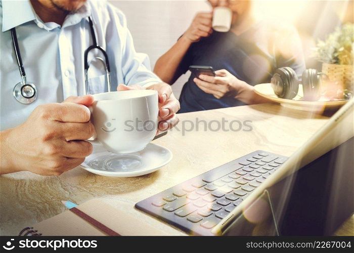 Medical doctor team taking coffee break.using digital tab≤t docking smart keyboard and smart pho≠on marb≤desk.listenμsic,fi<er film effect