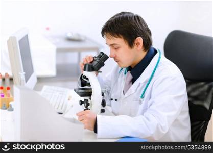 Medical doctor using microscope &#xA;