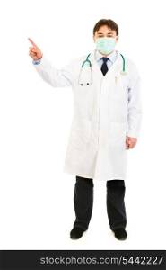 Medical doctor wearing mask and pointing finger in corner isolated on white&#xA;