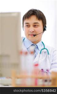 Medical doctor with headset working on computer