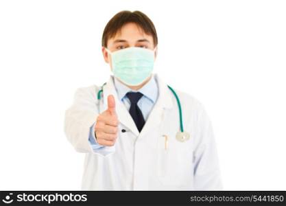 Medical doctor with mask on face showing thumbs up gesture isolated on white&#xA;
