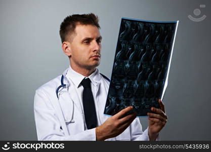 Medical doctor with MRI spinal scan portrait against grey background