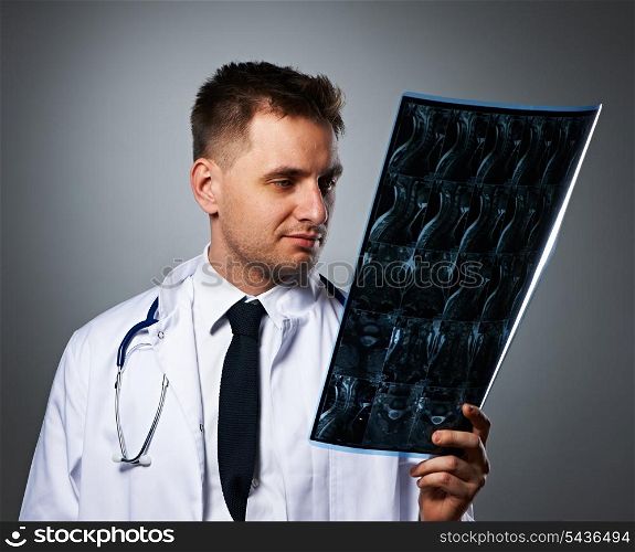 Medical doctor with MRI spinal scan portrait against grey background