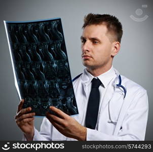 Medical doctor with MRI spinal scan portrait against grey background