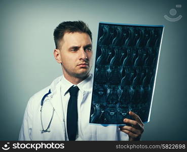 Medical doctor with MRI spinal scan portrait against grey background