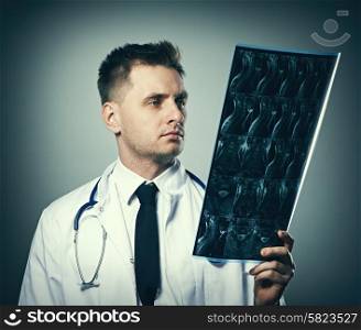 Medical doctor with MRI spinal scan portrait against grey background