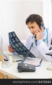 Medical doctor with patients tomography speaking phone