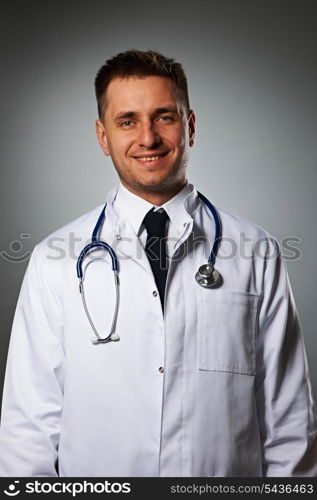 Medical doctor with stethoscope portrait against grey background