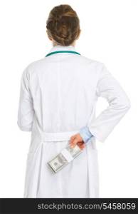 Medical doctor woman hiding pack of dollars behind back
