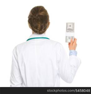 Medical doctor woman holding pack of dollars . rear view