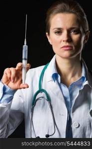 Medical doctor woman holding syringe isolated on black