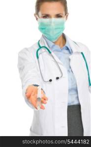 Medical doctor woman in mask showing syringe
