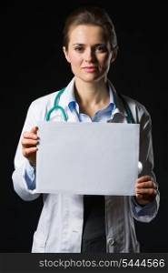 Medical doctor woman showing blank billboard isolated on black