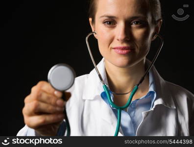 Medical doctor woman using stethoscope isolated on black