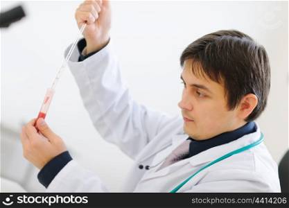 Medical doctor working with blood sample in laboratory