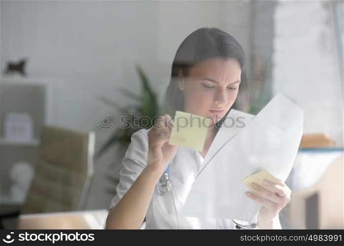 Medical doctor writing patient test results on transparent board to diagnose